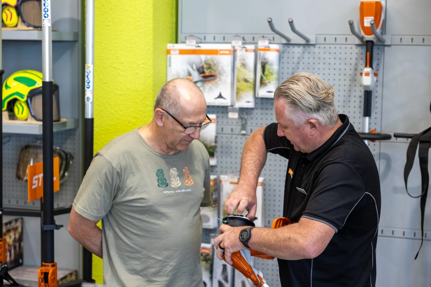A STIHL SHOP Mt Maunganui team member showing a customer a STIHL battery tool in the showroom