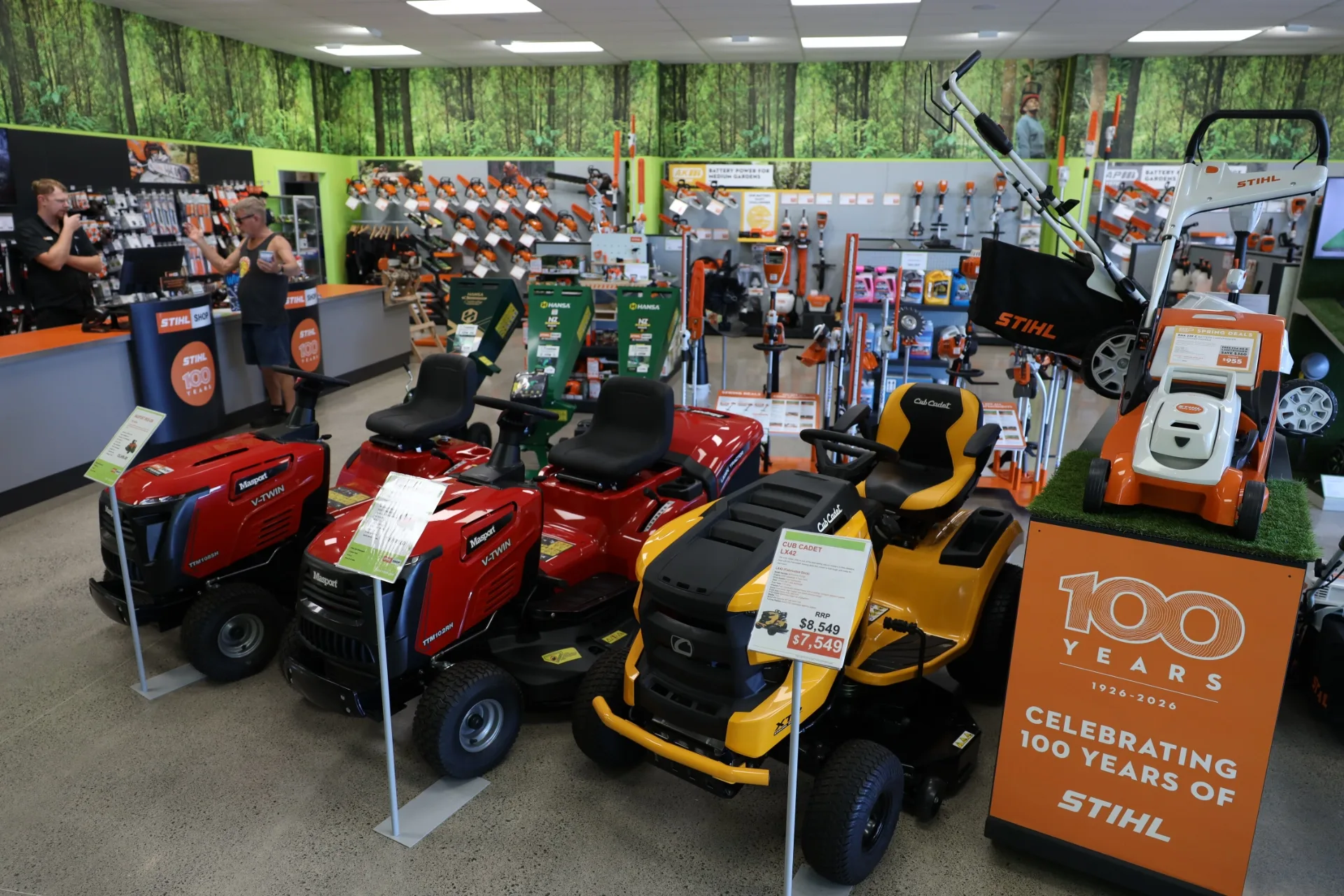 A STIHL SHOP Mt Maunganui team member showing a customer a Cub Cadet ride-on mower outside the store
