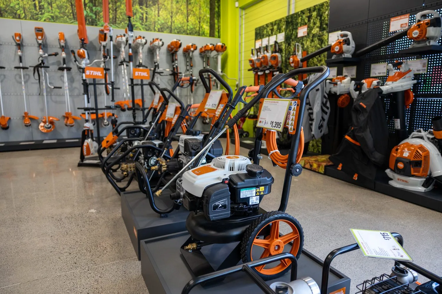 A STIHL SHOP Mt Maunganui team member talking with a customer beside a Cub Cadet ride-on mower outside the store