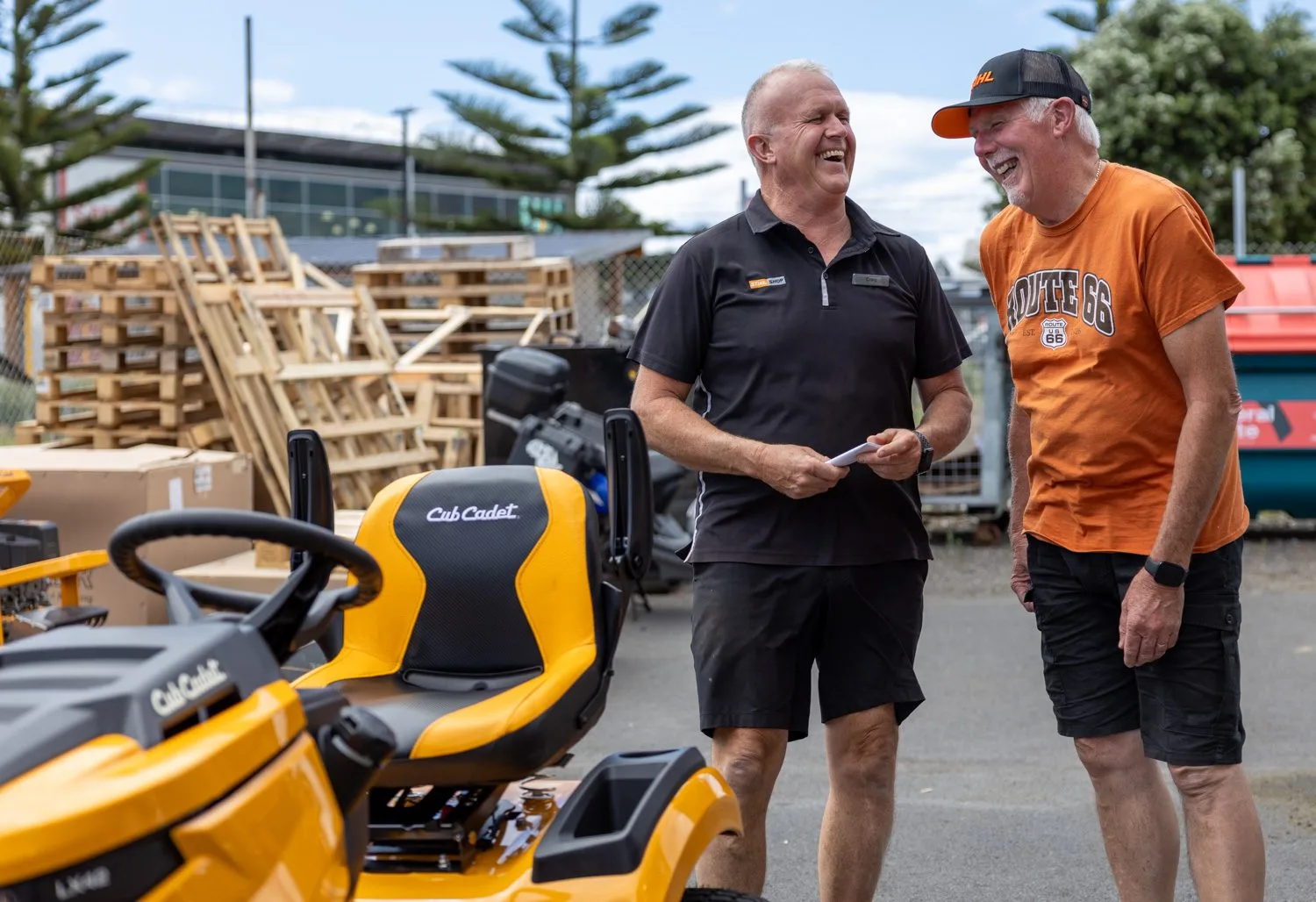 A STIHL SHOP Mt Maunganui team member and a customer beside a Cub Cadet ride-on mower